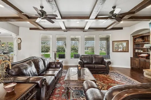 a living room with furniture a fireplace a flat screen tv and windows