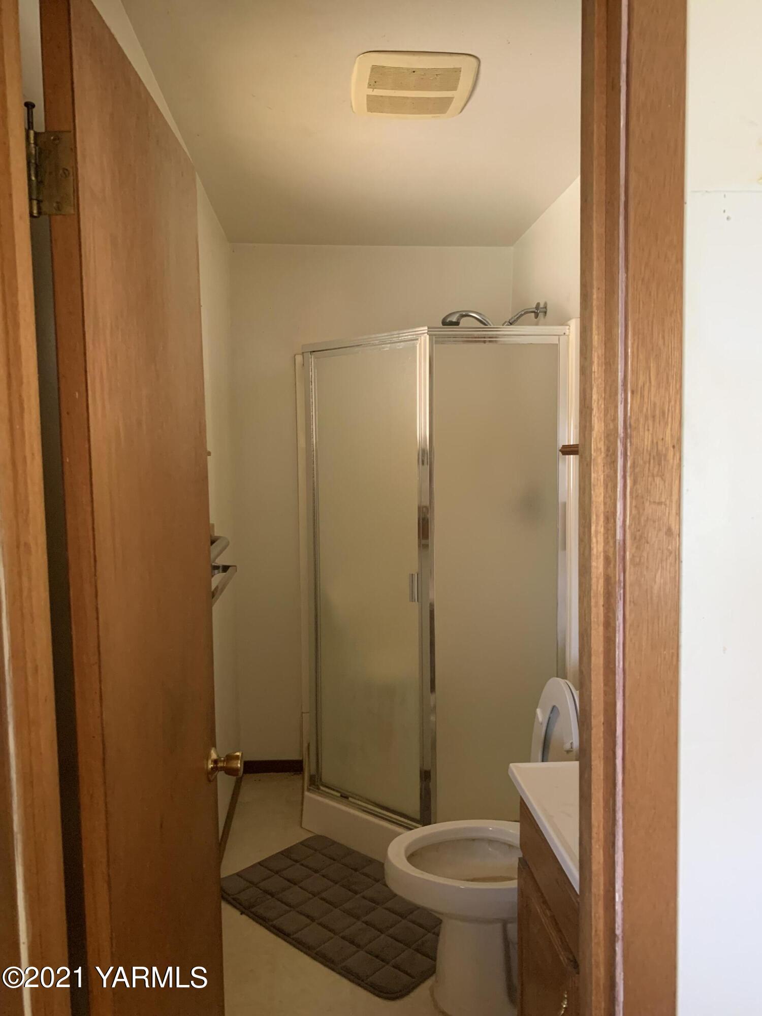 6807 Bell Road Yakima, WA 98901 - Photo 7 of 13 a bathroom with a granite countertop toilet and a shower