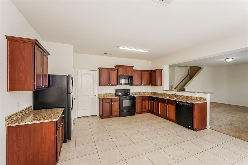 113 Rebel Road Venus, TX 76084 - Photo 5 of 17 a large kitchen with stainless steel appliances granite countertop a stove refrigerator and a sink