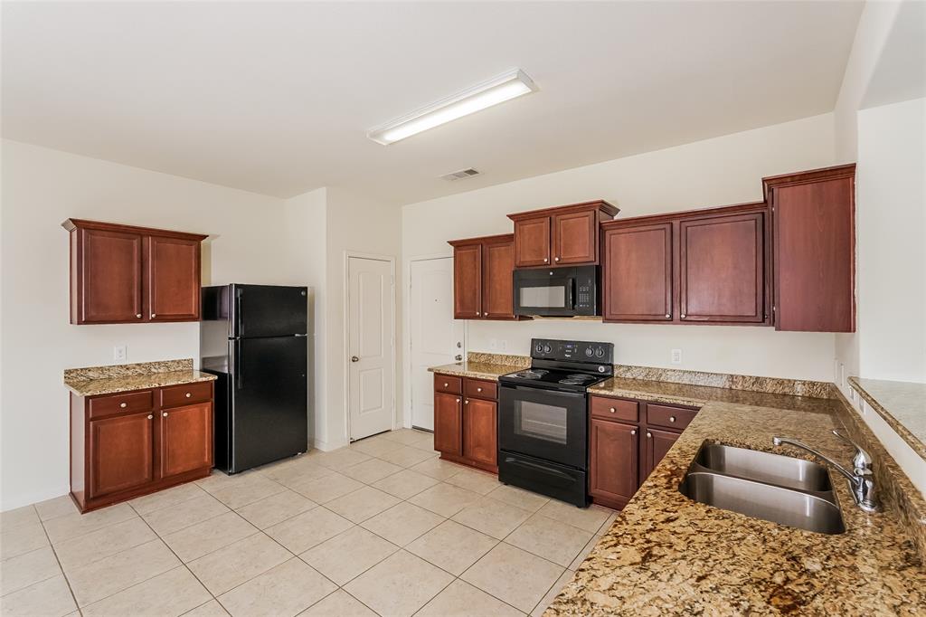 113 Rebel Road Venus, TX 76084 - Photo 7 of 17 a kitchen with stainless steel appliances granite countertop a refrigerator stove and sink