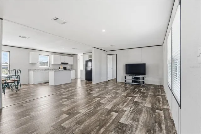 a view of kitchen with furniture flat screen tv and wooden floor