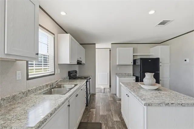 a kitchen with granite countertop kitchen island sink stove and granite counter top