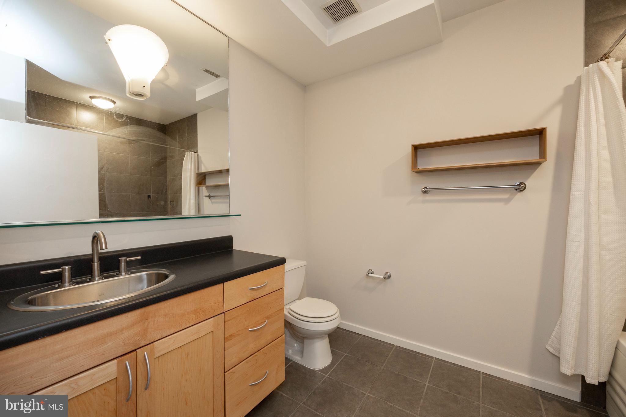 182 Gay Street, Unit 502 Philadelphia, PA 19128 - Photo 11 of 21 a bathroom with a granite countertop sink a toilet and a mirror