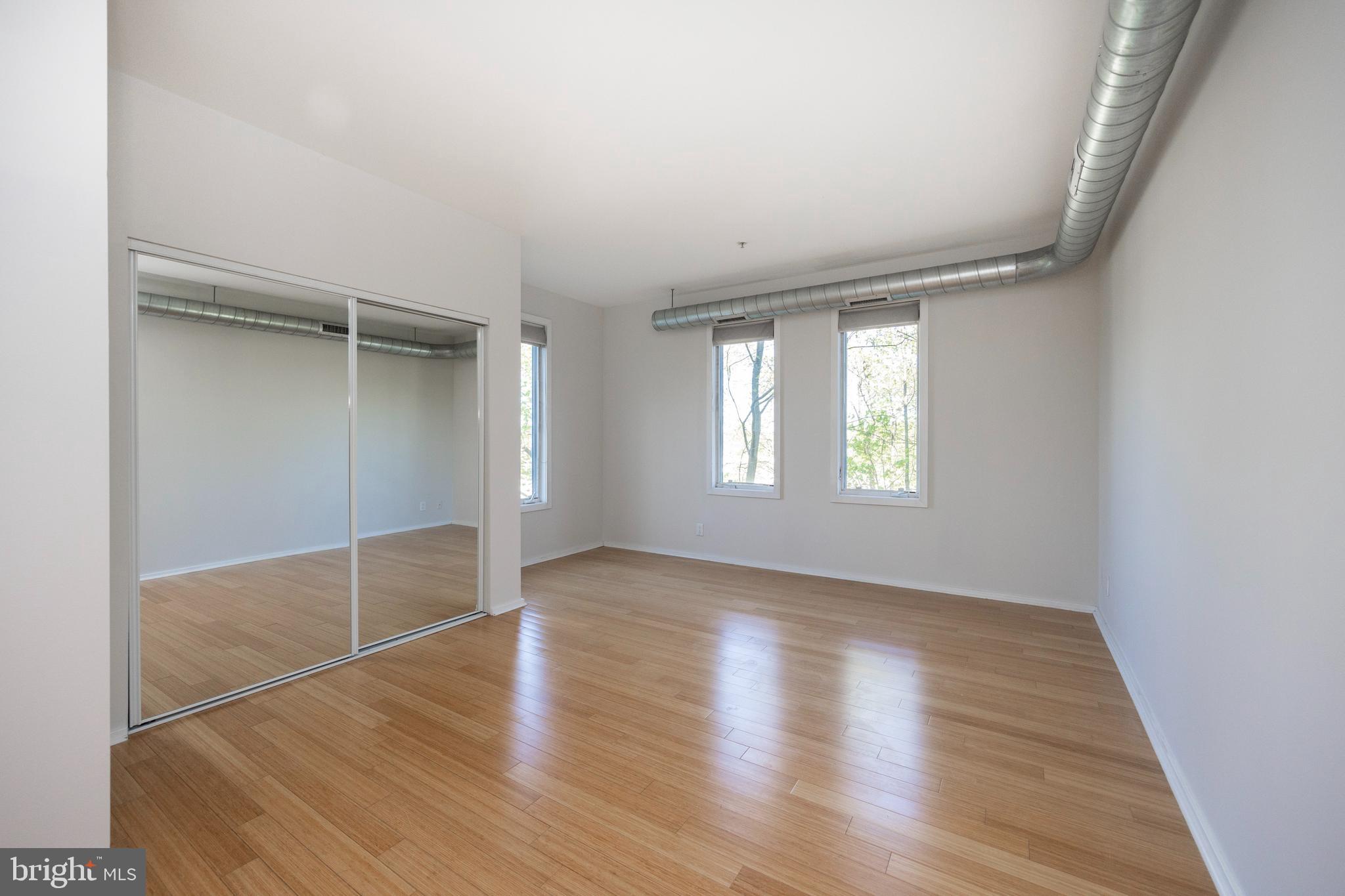 182 Gay Street, Unit 502 Philadelphia, PA 19128 - Photo 13 of 21 an empty room with wooden floor and windows