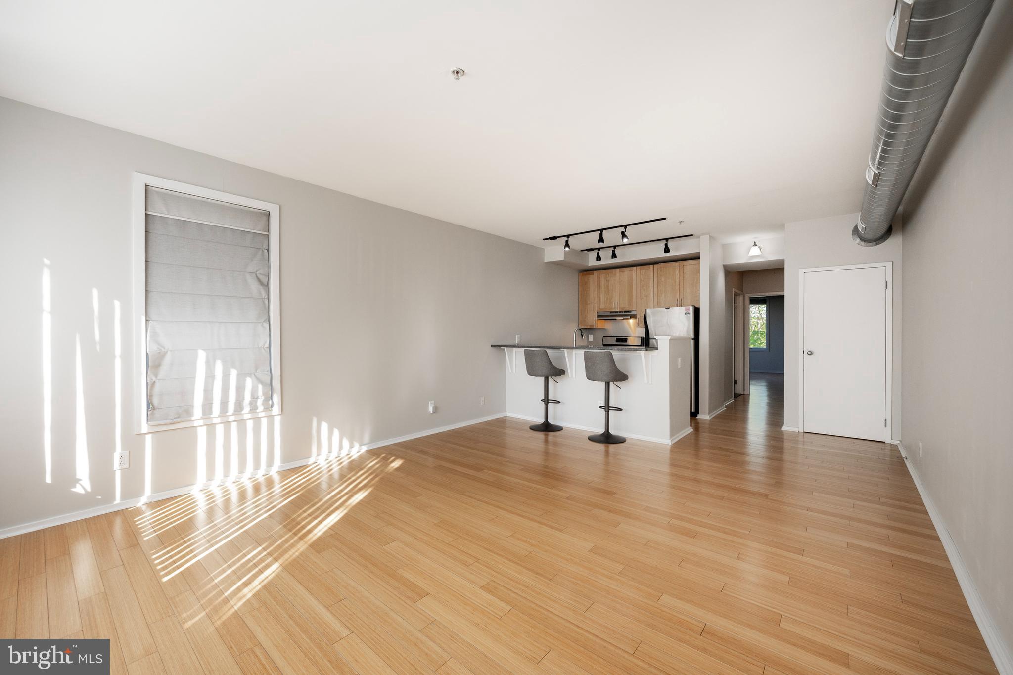 182 Gay Street, Unit 502 Philadelphia, PA 19128 - Photo 2 of 21 a view of an empty room with wooden floor and a window