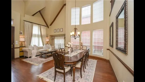 a dining room with furniture and large windows