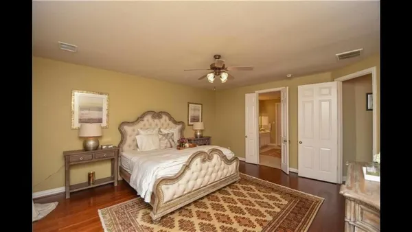 a spacious bedroom with a bed and a chandelier