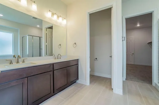 an empty room with wooden floor chandelier fan and windows