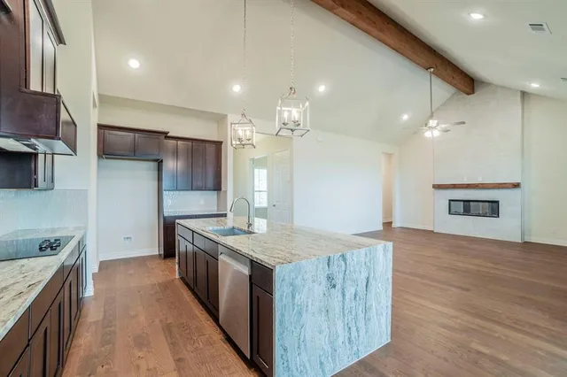 a kitchen with stainless steel appliances granite countertop wooden cabinets and a stove top oven