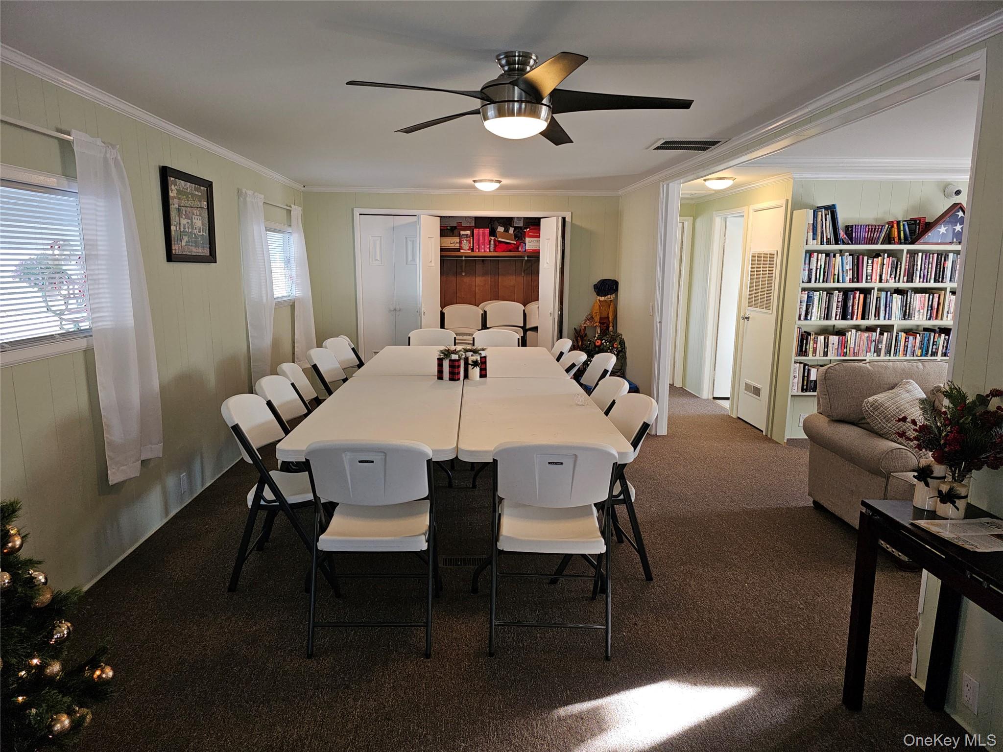 1964 River Road, Unit 35 Calverton, NY 11933 - Photo 15 of 16 Dining space featuring ornamental molding, dark colored carpet, and a ceiling fan