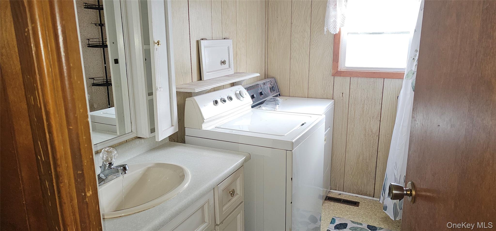 1964 River Road, Unit 35 Calverton, NY 11933 - Photo 7 of 14 Washroom with wooden walls, washing machine and clothes dryer, and light floors