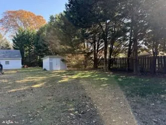 a view of a yard with wooden fence