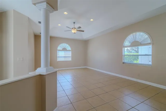 an empty room with windows and ceiling fan