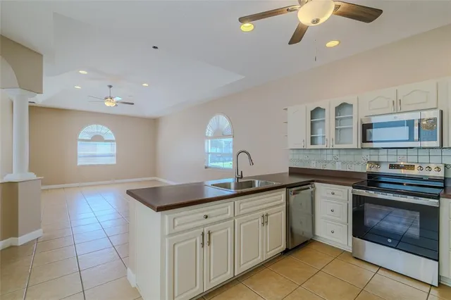 a kitchen with granite countertop a sink stainless steel appliances and cabinets