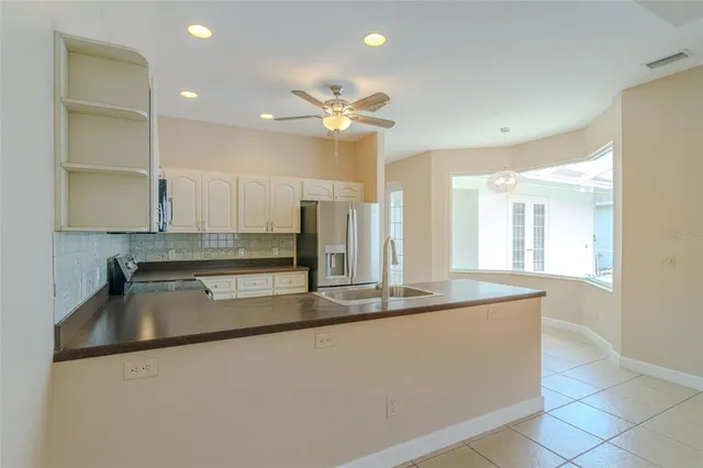 a kitchen with kitchen island a sink and a refrigerator