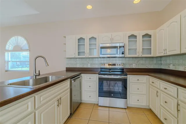a kitchen with stainless steel appliances granite countertop a stove sink and cabinets
