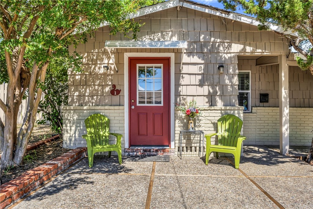 a front view of a house with outdoor seating and trees