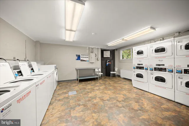 a large white kitchen with stainless steel appliances granite countertop a lot of cabinets and wooden floor
