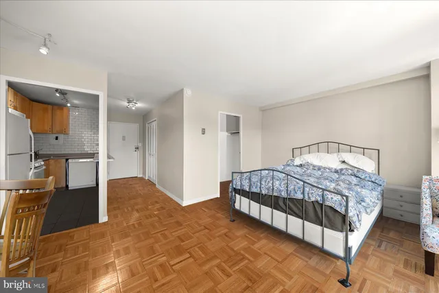 a bedroom with a bed and a view of kitchen