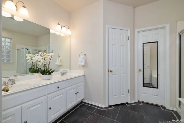 a spacious bathroom with a granite countertop sink a mirror and a