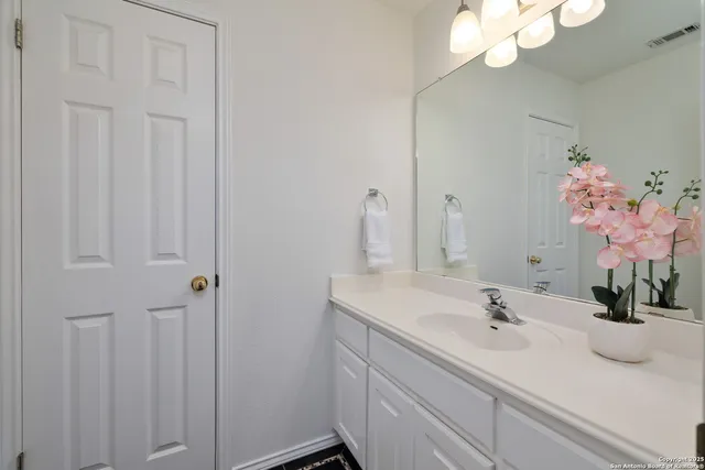 a bathroom with a sink vanity and a mirror