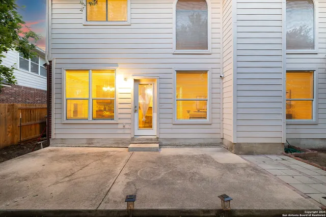 a view of a brick house with windows and plants
