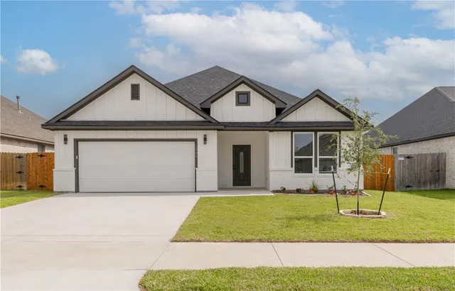 a front view of a house with a yard and entertaining space