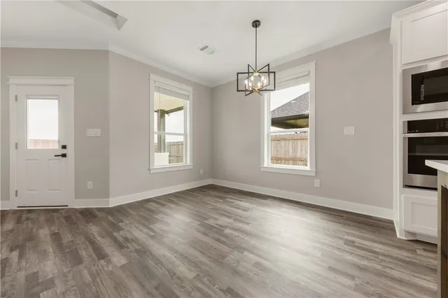 a view of empty room with wooden floor and window