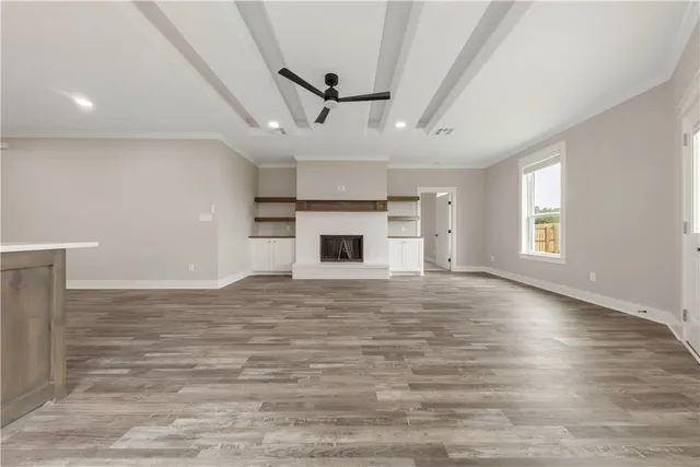 an empty room with wooden floor and fireplace