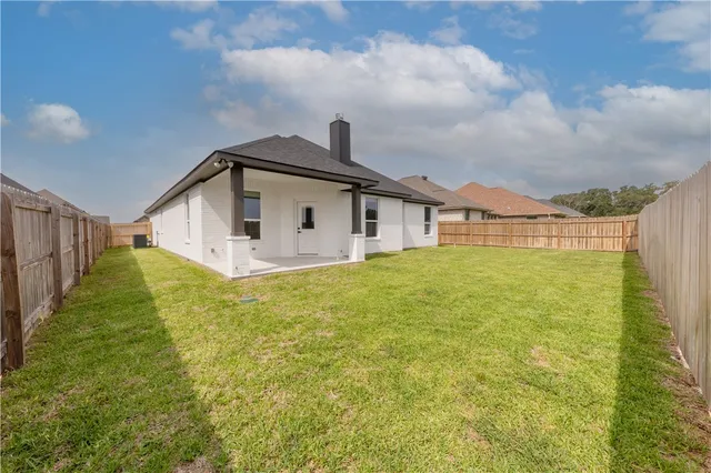 a white house sitting in middle of the green field