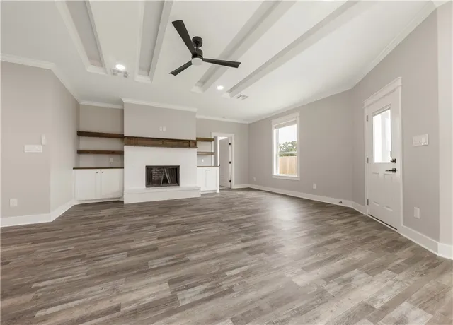 an empty room with windows and fireplace