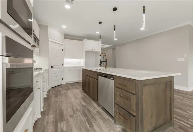 a kitchen with cabinets and wooden floor