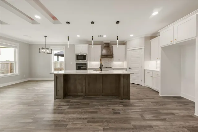 a large kitchen with kitchen island a sink stainless steel appliances and cabinets