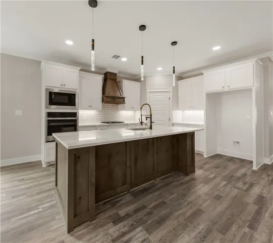 a kitchen with kitchen island granite countertop a sink and cabinets
