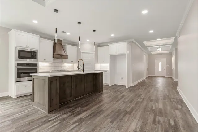 a kitchen with kitchen island a sink and a stove top oven