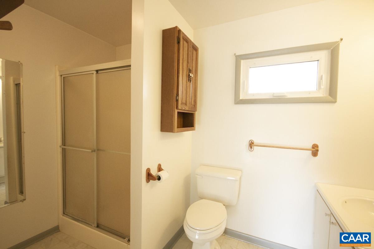 357 Logtrac Road Stanardsville, VA 22973 - Photo 17 of 36 a bathroom with a toilet sink vanity and shower