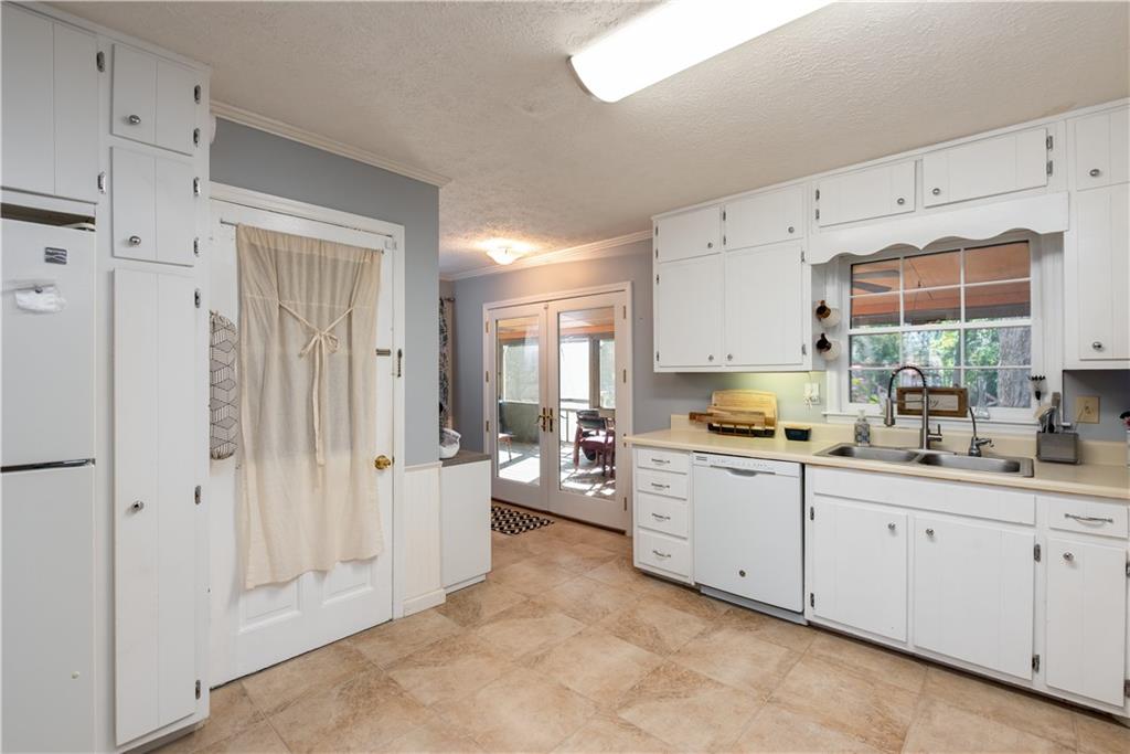 2598 Mountain View Road Snellville, GA 30078 - Photo 12 of 33 a kitchen with white cabinets and white appliances