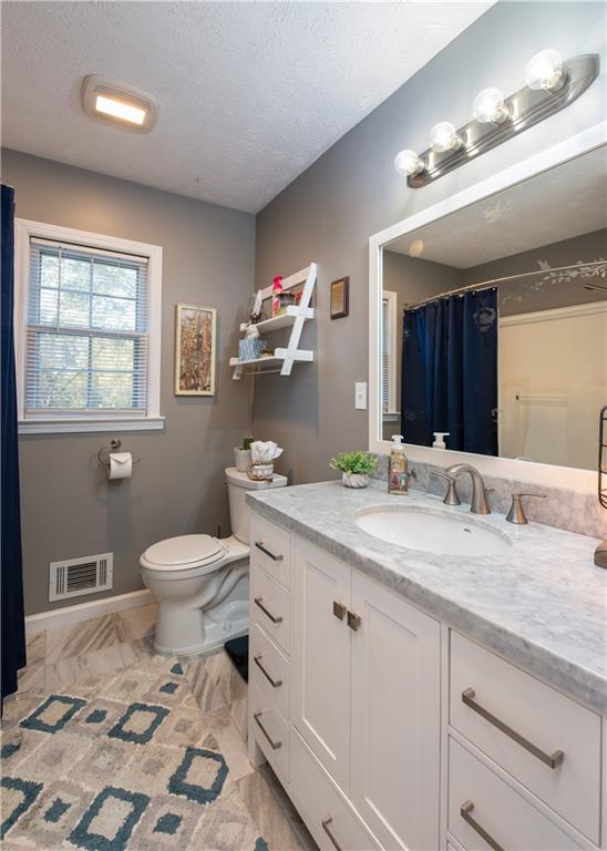 2598 Mountain View Road Snellville, GA 30078 - Photo 19 of 33 a bathroom with a granite countertop toilet sink and mirror
