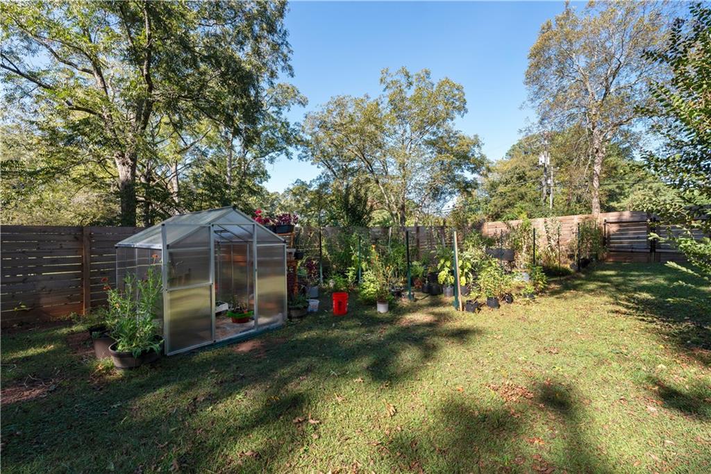 2598 Mountain View Road Snellville, GA 30078 - Photo 30 of 33 a view of a small house in a yard with potted plants and large trees