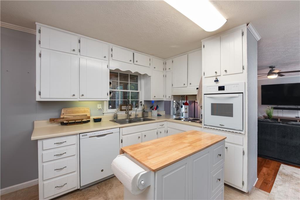 2598 Mountain View Road Snellville, GA 30078 - Photo 9 of 33 a kitchen with granite countertop white cabinets and white appliances