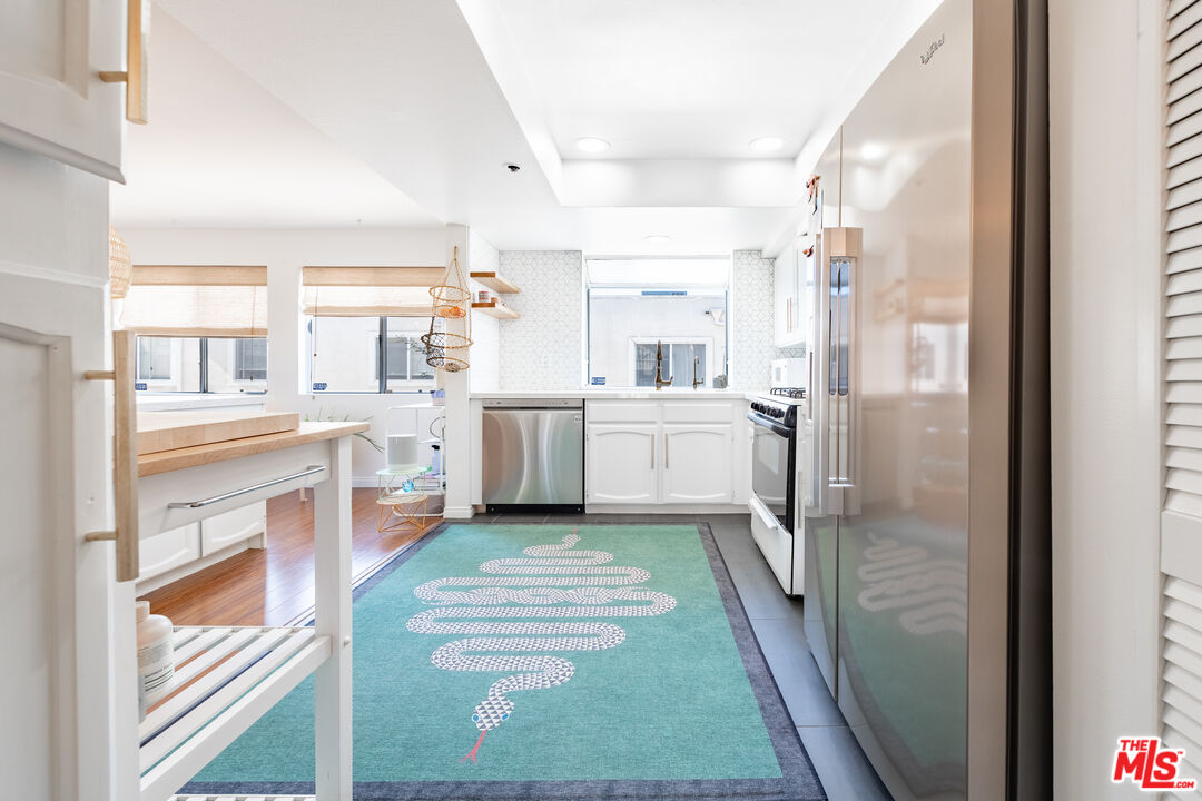 1001 Figueroa Terrace, Unit 305 Los Angeles, CA 90012 - Photo 4 of 18 a kitchen with white cabinets and white appliances