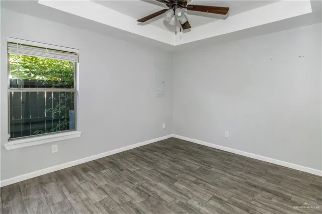 an empty room with a window and a fan