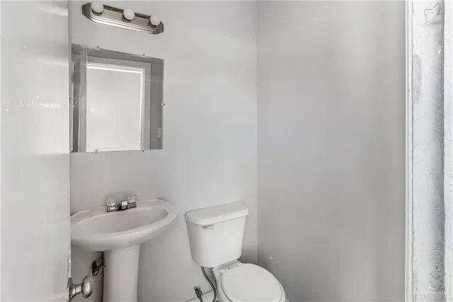 a bathroom with a toilet sink and mirror