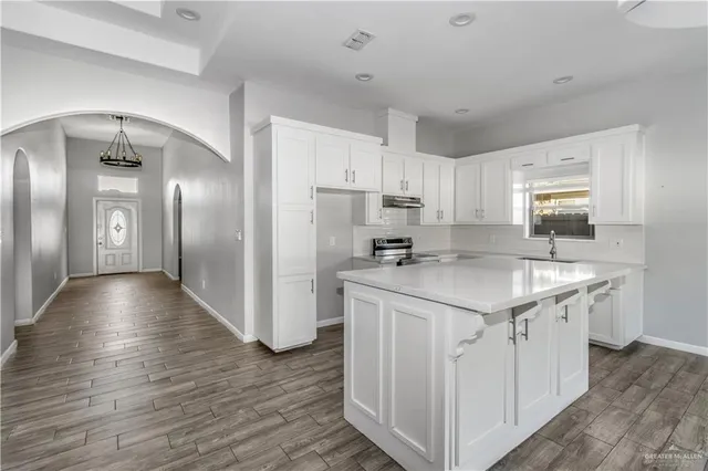a kitchen with a refrigerator a sink and cabinets