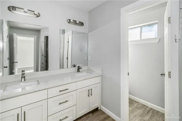 a bathroom with a double vanity sink and mirror