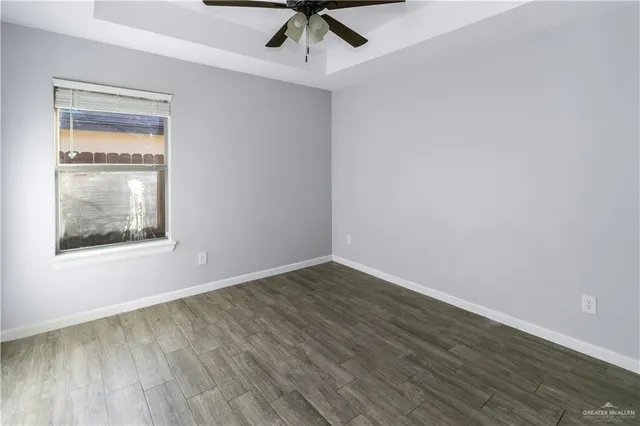an empty room with a window and ceiling fan