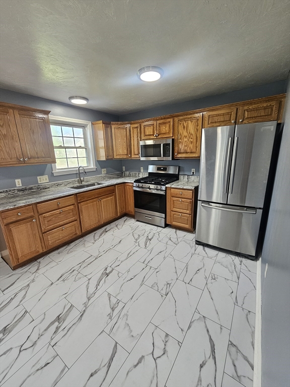 40 Merrick Street, Unit A Worcester, MA 01609 - Photo 2 of 32 a kitchen with stainless steel appliances granite countertop a refrigerator sink and stove