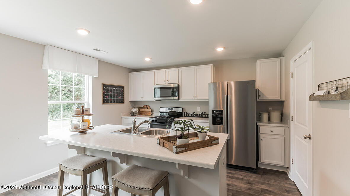 107 West 6th Street Howell, NJ 07731 - Photo 10 of 25 a kitchen with a refrigerator a sink a stove a dining table and chairs