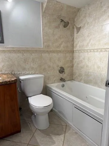a white toilet sitting next to a bathtub