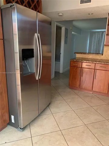 a metallic refrigerator freezer sitting in a kitchen